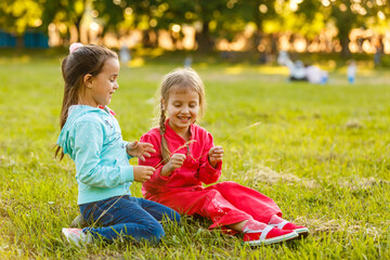 Adorable little girls having fun playing outdoors on summer day