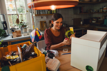 Smiling woman cleaning mess in kitchen at home
