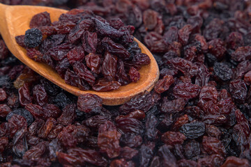 Close up of raisins in wooden spoon