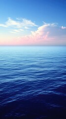 Obraz premium Serene Ocean View at Sunset with Soft Waves and Colorful Sky Reflections in the Background