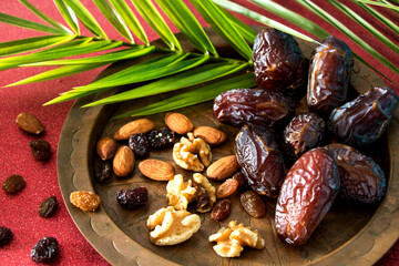 Teller mit köstlichen datteln, einer nussmischung und palmenzweig