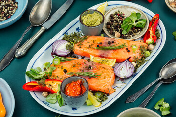 A plate of raw salmon with ingredients.