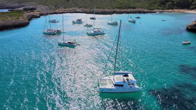 Experience the captivating beauty of Cala Varques in Mallorca as sailboats glide through crystal clear waters. This tranquil paradise offers a perfect escape for nature lovers and adventure seekers.