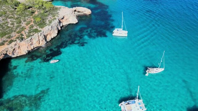 Sail through the crystal-clear turquoise waters of Cala Varques, surrounded by dramatic cliffs and vibrant scenery. Discover this beautiful location in Majorca, ideal for boating and relaxation.