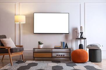 Tv set with white screen mounted on wall in room. Mockup for design