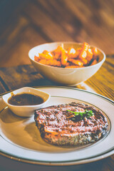 Grilled NZ Angus ribeye Steak served with homemade brown sauce, cajun fries