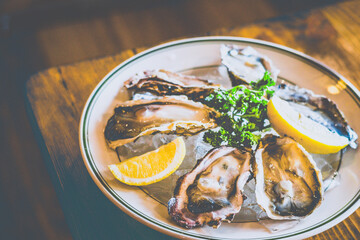 Half dozen raw oysters served on a bed of ice and with lemon wedges