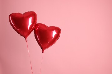 Two red heart-shaped balloons on pink background, space for text. Happy Valentine's Day © New Africa