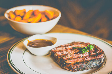 Grilled NZ Angus ribeye Steak served with homemade brown sauce, cajun fries