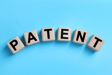 Obraz premium License. Word Patent made of wooden cubes with letters on light blue background, top view