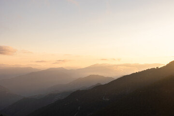 Fototapeta premium Landscape of the mountain range at sunset. Hazy mountains