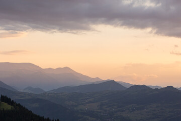 Mountain range with haze and partly cloudy sky at sunset