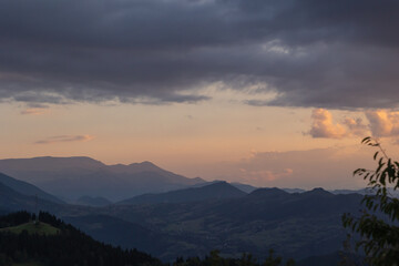 Mountain range with partly cloudy sky at sunset.