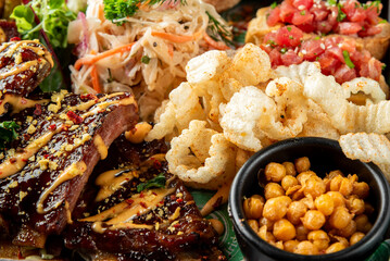 A vibrant plate featuring succulent BBQ ribs drizzled with sauce, crispy pork cracklings, tangy coleslaw, fresh salsa, and seasoned chickpeas, perfect for food lovers and culinary enthusiasts.