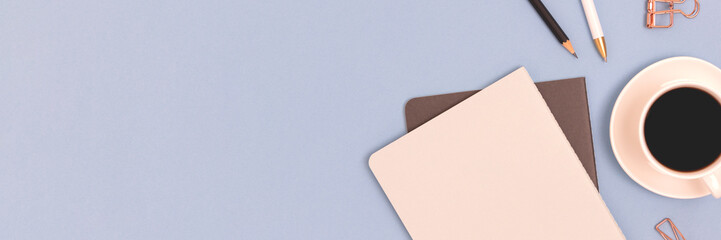 Banner with stationery and cup of coffee on a blue background.