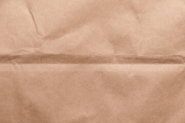 Crumpled brown wrapping paper with a single fold. Abstract background