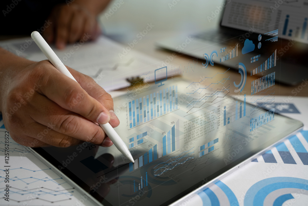 Poster businessman write statistics data on a tablet, which is displaying a graph analyzing sales data and 