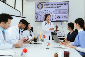 A diverse team of health care professionals, including doctors and nurses, sit and talk in a hospital office. The team works together to provide expert medical care and support to patients.