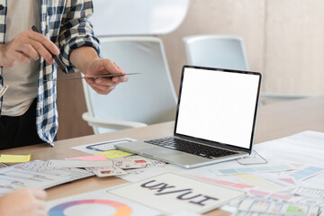 UXUI designer creating wireframes and prototypes at a modern workspace with laptop.