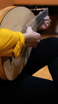 Video of a woman playing the baroque guitar, no faces shown 