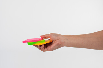 Paper stickers in hand. Hand holding a green sticker. Notes for the message.