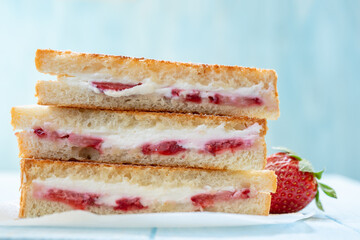 The sandwiches are made with white bread and strawberry jam