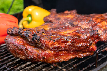A rack of ribs is being cooked on a grill