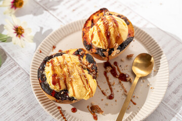 Two ice cream filled pastries with caramel drizzle on top