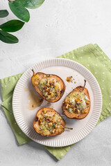 Three pears with cheese on top of a white plate