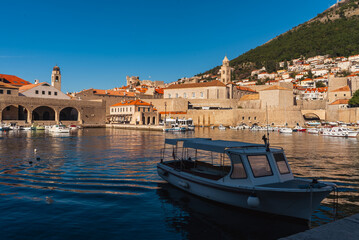 View of the city of Dubrovnik, Croatia. A mountain with a cable car. A moored boat stands in the foreground.