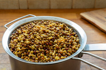 Soaked Nepalese green peas and fenugreek seeds on a strainer. Preparing Methi Kerau dish. 