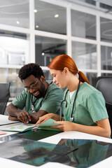 Fototapeta premium Caucasian woman doctor brainstorming and reading X-ray scan with diverse colleague