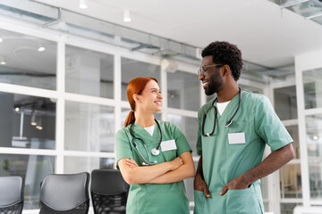 Female doctor and male colleague discussing health care strategies in hospital office