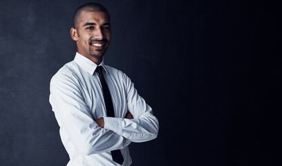 Obraz premium Happy, portrait and businessman with arms crossed on space for career development on a dark studio background. Man, employee or model with smile or confidence for creative job or startup on mockup