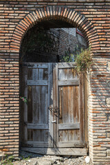 An old wooden gate in a stone arch
