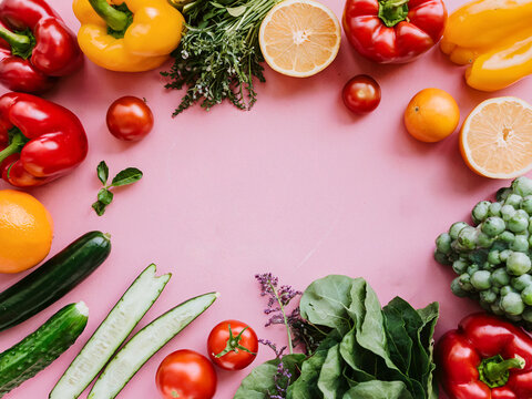 Colorful Assortment of Fruits and Vegetables on a Bright Pink Background