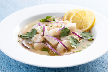 Traditional Peruvian ceviche sea bass fillet on blue background