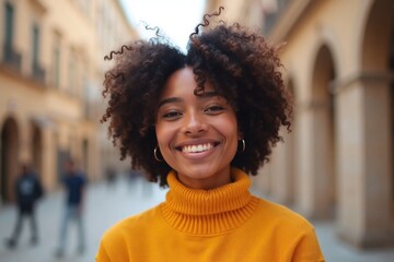 Fototapeta premium smiling woman with afro in yellow turtleneck outdoors
