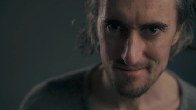 Evil Character Portrait Young attractive European male with large eyes and long hair depicted in cold tones showcasing a serious villainous expression