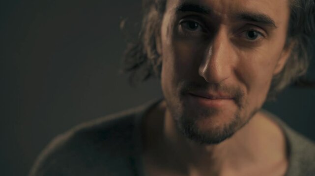 Disagreeing Young Man Young attractive European male with big eyes and long hair shakes his head to convey disapproval in a cinematic setting