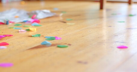 A vibrant array of colorful confetti is scattered across the wooden flooring, perfectly capturing the festive atmosphere and showcasing the potential decor for various upcoming events