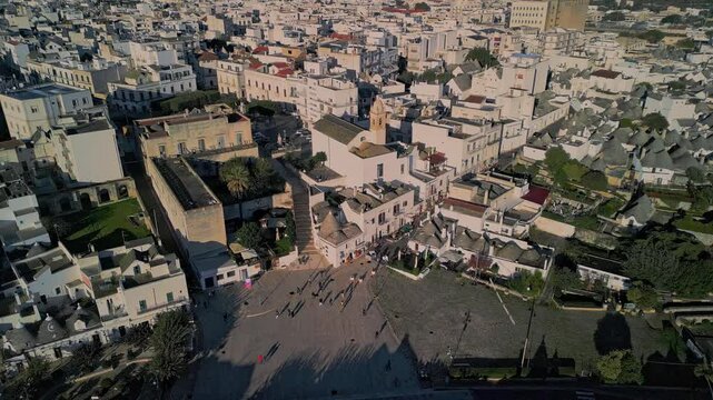 flight over the center of Alberobello. city is famous not only for amazing architecture of the Truli houses, but also for true architecture of Italy. white houses with tiled roofs in the setting sun