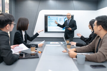 Fototapeta premium Businessman, woman and man presenting, office meeting with documents, laptop, sales planning, digital marketing and growth strategy, analysis with colorful charts and graphs about sales planning.