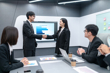 Businessman, man and woman shaking hands, meeting in office with documents, laptop, planning sales, digital marketing and growth strategy, analysis with colorful charts and graphs about sales planning