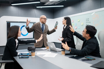 Male software developer meeting in modern office with stressed employees, documents, laptops, sales...