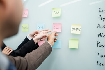 Businessman, woman, smiling, holding laptop, post-it notes, sales planning, digital marketing, growth strategy, marketing goals, analysis with colorful charts and graphs.