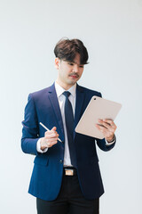 Young Asian businessman working with tablet in hand isolated on white background,portrait of young...