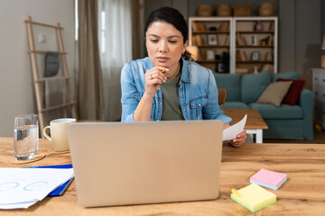 Young confident businesswoman working at home office on laptop computer. Business owner...