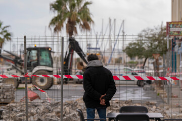 Hombre mirando las obras en la calle