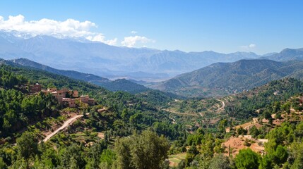 Obraz premium Winding pathways carve through the stunning Atlas Mountains, showcasing terraced fields and charming villages under a clear blue sky. Nature thrives, inviting exploration and peace